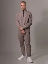 Buzo color topo de Calvin Klein, con cuello alto y media cremallera negra.