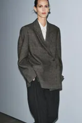 Blazer Zara Woman Collection confeccionada en tejido con lana, de corte oversize. Presenta cuello con solapas de muesca, cierre frontal cruzado con un botón y bolsillos de vivo en el delantero. Incluye forro interior.