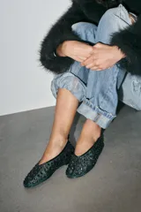 Zapato tipo bailarina color verde con apliques de strass plateados, confeccionado en mesh. Tiene tirador trasero y terminación en punta redonda. La suela mide 1 cm.