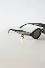 Lentes de sol negros con forma geométrica y protección UV400. Incluye estuche.