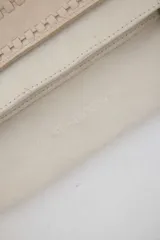 Cartera bandolera de gamuza azul marino con flecos en los laterales y solapa frontal decorada con detalle de cuero liso. Cuenta con asa ajustable y herrajes metálicos plateados.