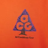 Remera Nike ACG de alta densidad en color naranja, de corte amplio y relajado, con cuello redondo de canalé y gráfico estampado en el pecho.