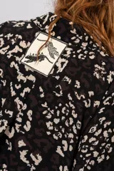 Vestido camisero midi negro con estampado floral blanco, de corte recto y manga corta.