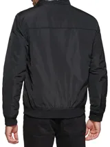 Campera bomber Tommy Hilfiger negra de poliéster, con cuello alto, cierre frontal con cremallera, dos bolsillos laterales con cremallera, puños elásticos y logo bordado en el pecho.