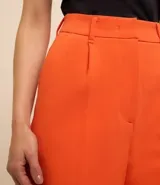 Short negro de tiro alto confeccionado en crepé con trabillas en la cintura, cierre tradicional, pliegues y recortes traseros.