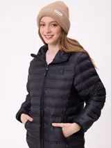 Gorro tipo beanie de punto acanalado color bordó, con etiqueta rectangular blanca con logo de la marca en el frente.