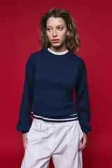 Sweater azul marino de tejido rib, con hombros estructurados, cuello redondo y mangas abullonadas con puños elásticos.
