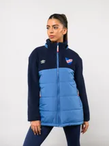Parka de abrigo Umbro del Club Nacional de Football, con diseño bicolor que combina tejido polar blanco en la parte superior y tejido acolchado azul marino en la parte inferior. Cuenta con cierre frontal completo, cuello alto y bolsillos laterales.