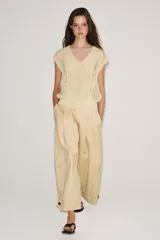Chaleco de punto de tejido rústico color beige, con escote en V y diseño sin mangas.