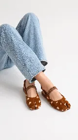 Chatitas estilo Tabi en cuero color chocolate, con diseño de punta dividida, tira elástica fruncida en el empeine y tira trasera con hebilla ajustable.
