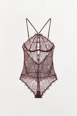 Body de encaje color vino tinto, con aros en la copa, cuello halter con tirantes finos ajustables y detalle de abertura en el centro del pecho. Presenta bordes festoneados.