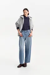 Camisa de manga larga con cuello, silueta amplia y cierre frontal abotonado. Presenta un estampado a cuadros en tonos azul marino y gris.