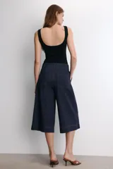 Body negro de escote cuadrado y tirantes anchos, con cierre de broches en la parte inferior.