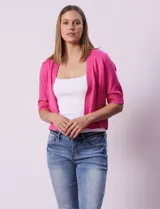 Cardigan de punto color beige, de corte corto y manga corta. Presenta un diseño abierto sin cierre frontal y detalle de tres botones decorativos en el puño de cada manga.