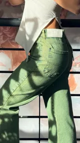 Pantalón jean verde de corte recto y tiro medio, con bolsillos delanteros y traseros.