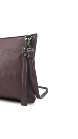 Sobre de mano de símil cuero con diseño de franjas diagonales en negro, blanco y marrón. Cuenta con cierre metálico frontal, bolsillo interior con cierre y otro abierto con división. Incluye correa desmontable para usar como bandolera.