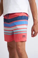 Short de baño con cintura elástica y cordón ajustable, confeccionado en tela ligera de secado rápido. Presenta un estampado botánico integral en tonos amarillos, blancos y azules, con dos bolsillos delanteros y uno posterior.