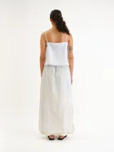 Blusa celeste claro con tirantes finos, escote en V y diseño abierto al frente con lazos para atar.