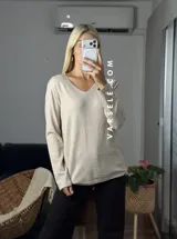 Sweater de punto color bordó con escote en V y detalle de strass aplicado en la parte frontal. Presenta mangas largas y corte holgado.