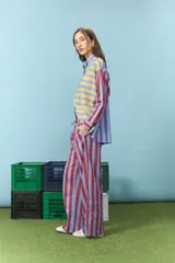 Pantalón de corte recto y tiro medio, confeccionado en algodón con estampado de rayas verticales en tonos rojo y azul. Cuenta con cintura elástica con cordón de ajuste.