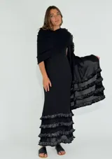 Vestido largo negro con breteles finos y escote redondo. Presenta tres volados de encaje calado en el ruedo.