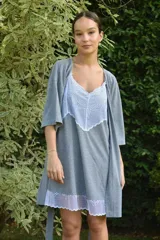 Camisón de algodón color beige con escote en V y ruedo decorados con puntilla gris. Presenta breteles finos y corte recto.