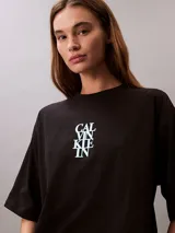 Remera de corte oversize confeccionada en algodón, con cuello redondo y mangas cortas. Presenta un estampado frontal con el logo de la marca en disposición vertical.