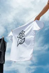 Remera blanca de manga corta con un estampado grande de una flor dibujada a mano en color negro.