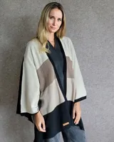 Ruana de lana lambswool con diseño de bloques de color en tonos beige, marrón y negro.