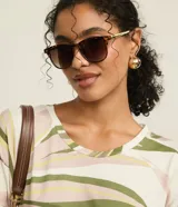 Blusa estilo remera de cuello redondo y manga corta, confeccionada en viscosa con estampa de follaje en tonos verdes y rosados sobre base blanca.