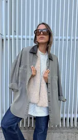 Sobrecamisa de denim en color gris con lavado desgastado, corte oversize y cuello de cuero sintético en color marrón chocolate. Cuenta con cierre frontal de botones metálicos.