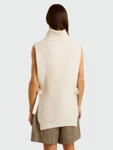 Chaleco de lana color crema con cuello alto y lazos laterales.