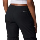 Pantalón largo negro convertible en short, de tiro medio con presillas para cinturón y bolsillos laterales, ideal para actividades al aire libre y trail.