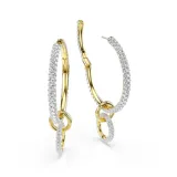 Caravanas de aro de la colección Dextera, con diseño de tres anillos interconectados con baño en tono oro y engastados con cristales transparentes. La sección colgante es removible para mayor versatilidad.