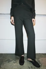 Pantalón de tiro medio con corte cropped flare, confeccionado en tejido con viscosa. Presenta detalle de raya planchada, bolsillos laterales y cierre frontal con cremallera, botón y ganchos metálicos.