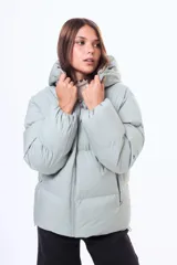 Campera puffer de corte holgado en color beige, con capucha integrada, cierre frontal completo y bolsillos laterales. Presenta un diseño acolchado con acabado mate y puños elásticos.