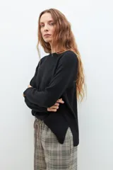 Sweater de punto en color celeste, con cuello redondo, mangas largas y puños acanalados. Presenta un diseño de corte holgado con costuras verticales decorativas en el frente.