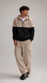 Pantalón cargo de corte holgado en color beige, con bolsillos laterales tipo cargo y cierre frontal.