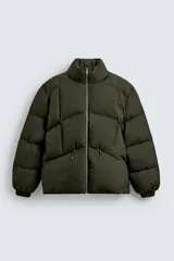 Cazadora acolchada de corte relajado confeccionada en tejido técnico color verde militar. Presenta cuello subido, cierre frontal con cremallera, mangas largas con puños elásticos y bolsillos frontales con cremallera oculta.