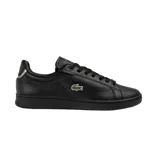 Championes Lacoste modelo Carnaby Pro, color negro con textura granulada. Presentan el logo del cocodrilo bordado en el lateral, cordones al tono y detalle metálico en el talón.