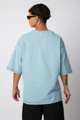 Remera manga corta color lila con costuras blancas a la vista.