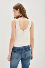 Musculosa de punto compacto, color blanco, con escote en V pronunciado y calce al cuerpo.