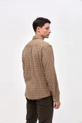 Camisa de corte regular fit confeccionada en algodón, con estampado de cuadros, cuello solapa clásico, cierre frontal con botones y dos bolsillos en el pecho.