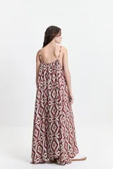 Vestido largo de silueta amplia y fluida, con breteles finos y escote redondeado. Presenta un diseño estampado con motivos geométricos en tonos bordó, beige y gris.