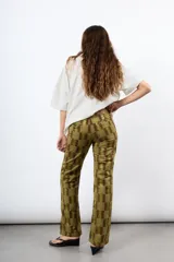 Pantalón de pana tiro alto color óxido, de corte flare y pierna ancha. Cuenta con botonadura frontal metálica y bolsillos plaqué delanteros.