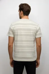 Remera de manga corta con cuello redondo, confeccionada en algodón con estampado botánico de hojas en tonos verdes.