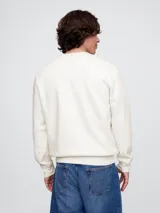 Buzo deportivo Gap color crudo, de corte recto, con cuello redondo y logo Gap NYC estampado en verde.