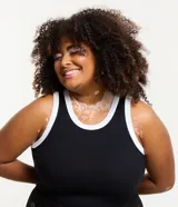 Musculosa negra de ribana con cuello redondo y sisas con ribete blanco en contraste.