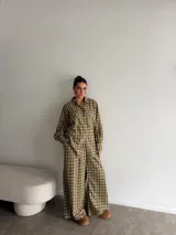 Pantalón de corte ancho y tiro alto con estampado de cuadros en tonos verdes y beige. Presenta una caída fluida y holgada.