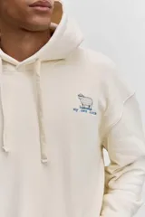 Buzo con capucha y bolsillo tipo canguro, de color crema, con pequeño estampado en el pecho y cordones ajustables en el cuello.